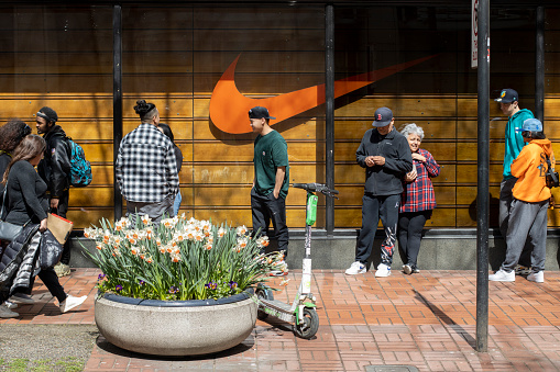 Portland, OR, USA - Apr 1, 2022: Nike fans wait in line outside the Nike's Flagship Store in downtown Portland, Oregon, to buy new release sneakers.