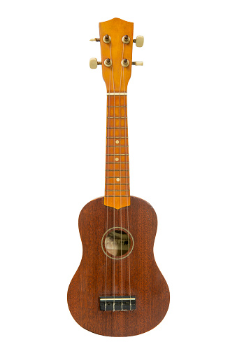 The old brown ukulele on the white background