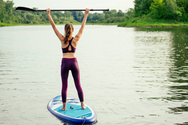 woman on sup sup board in nature at evening.