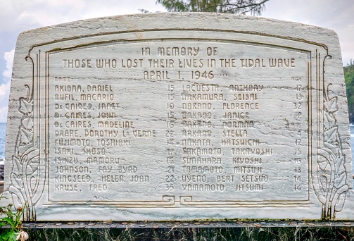 Laupahoehoe Point, Big Island, Hawaii - March 7, 2015. A memorial stone listing the names and ages of the 24 victims killed in the village school by a tsunami which struck the Hawaiian Islands on April 1, 1946.