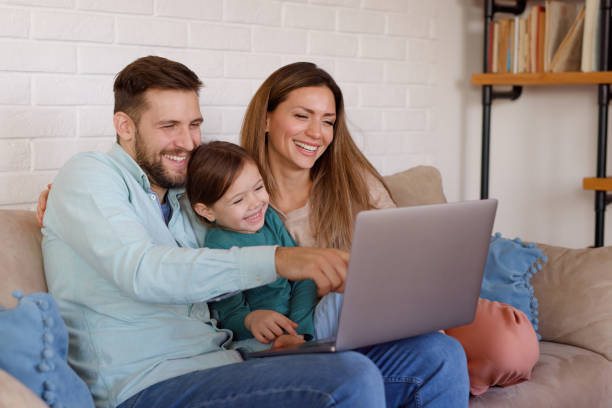 istock Smiling family relaxing at home and using laptop together 1391552979