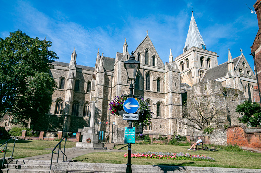 Rochester Cathedral at Medway in Kent, England, with people sunning themselves in a small public park.