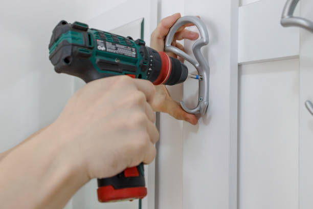 istock Handyman installing coat hanger on a door, close up 1391554282