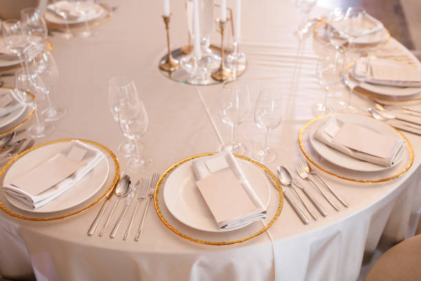 istock Tables setting at a luxury wedding. Table for guests. Dishes and drinks. Floral decorating, white chairs and table. Wedding table preparation. top view. Horizontal photo 1391557407
