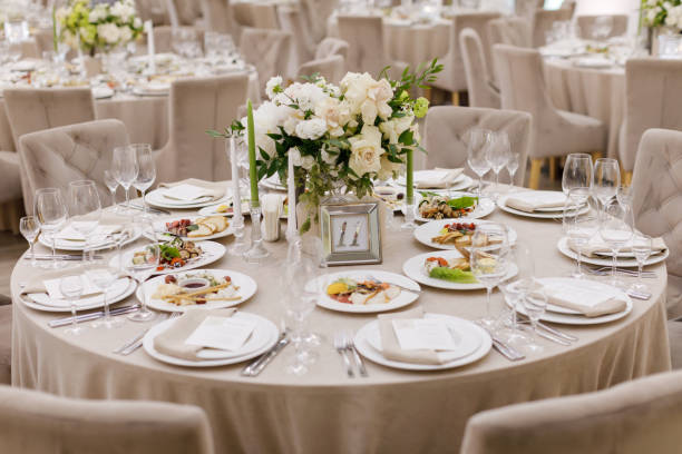 istock Tables setting at a luxury wedding. Table for guests. Dishes and drinks. Floral decorating, white chairs and table. Wedding table preparation. top view. Horizontal photo 1391557453