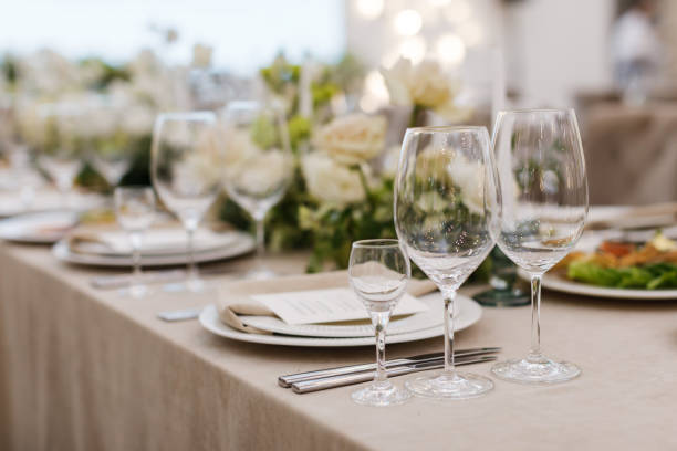 istock Tables setting at a luxury wedding. Table for guests. Dishes and drinks. Floral decorating, white chairs and table. Wedding table preparation. top view. Horizontal photo 1391557456