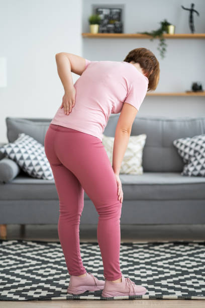 Back pain, kidney inflammation, woman suffering from backache at home stock photo