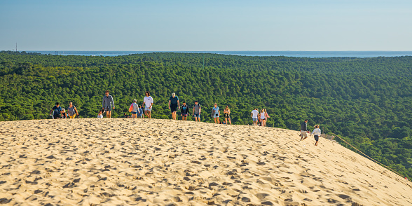 Tourists visiting the top of the Dune du Pilat and Landes forest on a summer day in Gironde, France