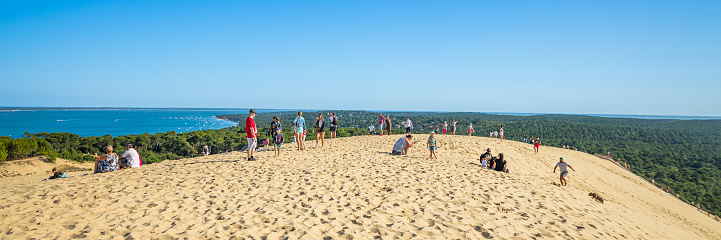 Panoramic view of tourists visiting the top of the Dune du Pilat in Gironde, France during summer