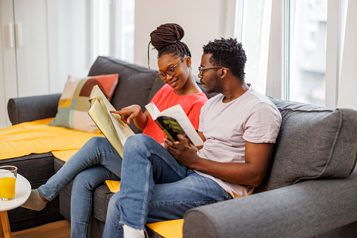 Black man and black woman reading book. Literary genre concept.