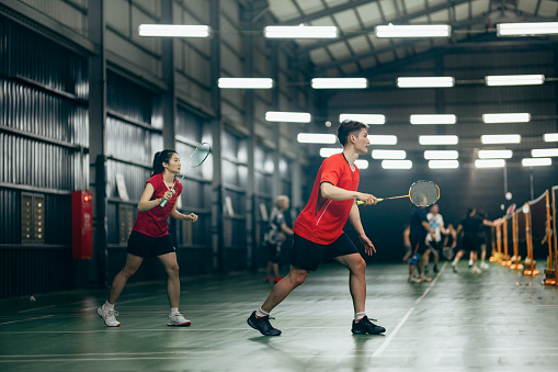 Taiwanese badminton players warm up exercise practicing in badminton court endurance training
