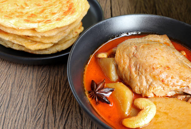 Chicken Massaman curry served with roti parata or roti canai on old wood backgroud. Delicious Thai food. Chicken Massaman curry served with roti parata or roti canai on old wood backgroud. Delicious Thai food. roti canai stock pictures, royalty-free photos & images