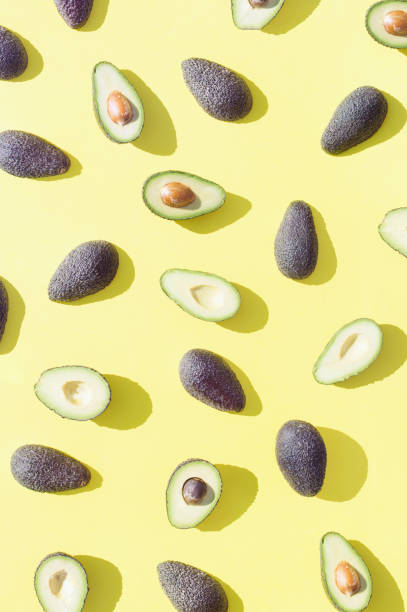 istock Dark green avocados on a yellow background. 1391564498