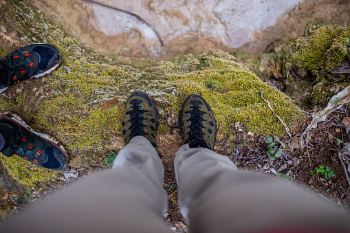 Point view of unrecognizable man and woman, and their hiking boots while traveling and exploring nature