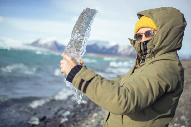 The woman holds the ice in her hands. ISL