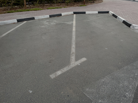 Empty public parking spaces for vehicles on the side of a street in Dubai, United Arab Emirates.