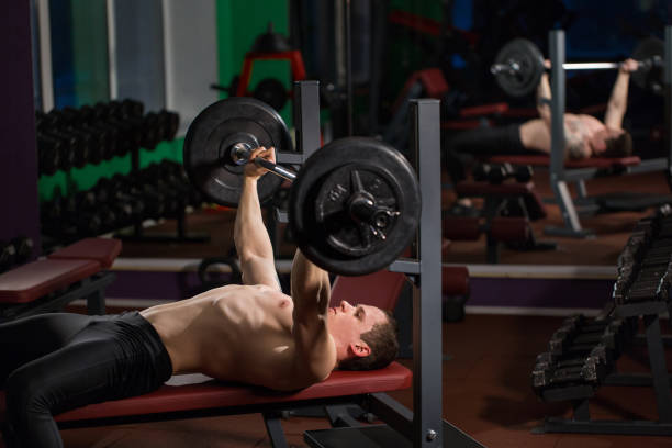 istock Brutal athletic man pumping up muscles on bench press. 1391565531