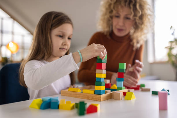 istock Joyful mother and her daughter playing with multi colored toy blocks 1391565640