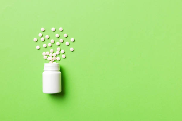 istock Multicolored pills and capsules in plastic bottle on Colored background, copy space. Many different various medicine tablets and pills, vitamin and nutritional supplements concept 1391566878