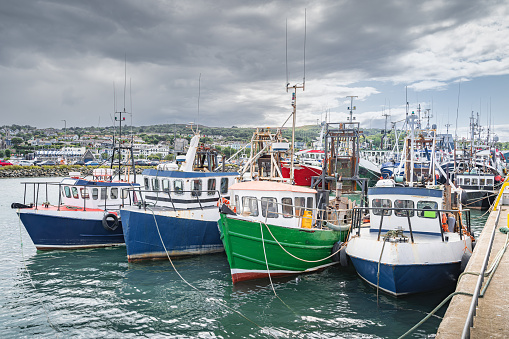 Four small fishing boats moored in Howth harbour. Phishing and shellfish fishing equipment on fishing boats, Dublin, Ireland