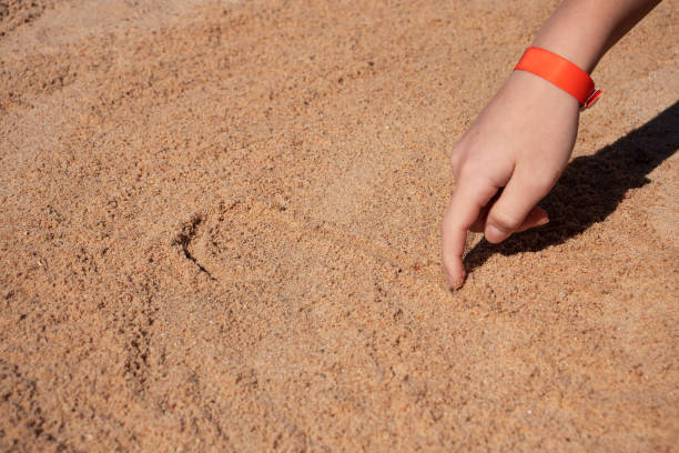 istock boy draws on the sand by the sea in summer 1391573570