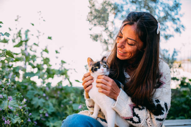 istock Young Woman Hugging Her Cat in the Garden 1391574419