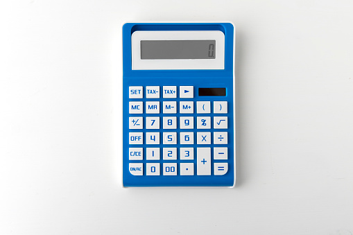Blue calculator un white desktop - Business, finance or education concept.