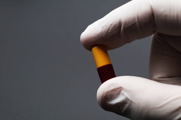 istock Doctor's hand with a capsule, antibiotic, or medicine pill 1391576409