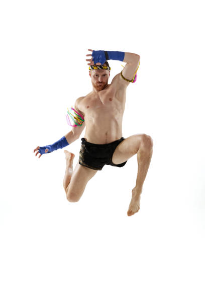 istock Knee kick. Portrait of professional thai boxer practicing isolated on white studio background. Sport, muay thai, competition, fight club concept 1391577020