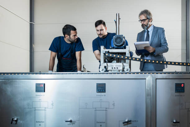 istock Quality inspector supervising manual workers in a factory. 1391579130