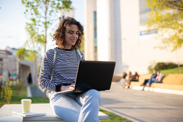 istock Young student girl smiling happy using laptop at the university 1391579237