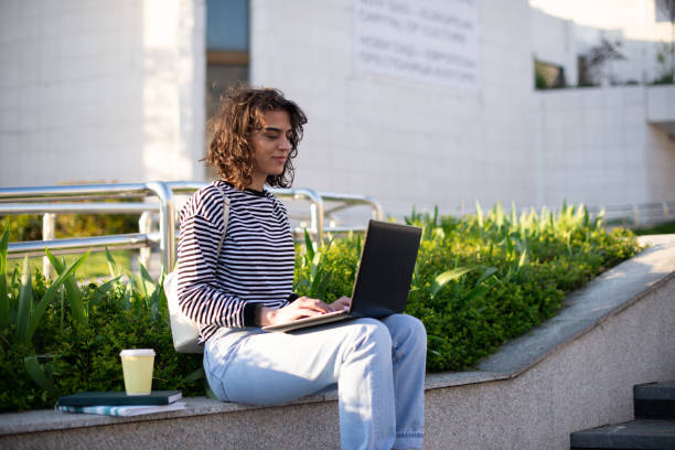 istock Young student girl smiling happy using laptop at the university 1391579306