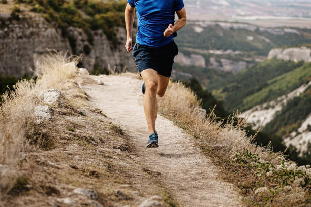 istock male runner running trail on cliff edge 1391579318