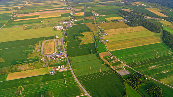 Aerial view of road passing through agricultural fields and farms in Montreal, Quebec, Canada.