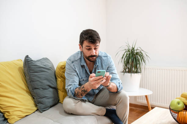 istock Attractive man surprised after receiving a text message 1391582098