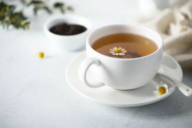 Healthy homemade chamomile tea in a white cup