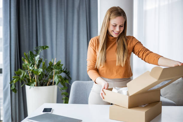 istock Young woman unpacking her online purchase 1391582272