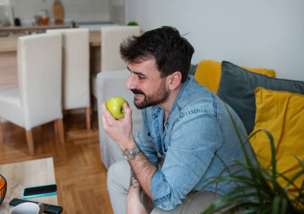 istock Handsome young man eating a green apple 1391583036