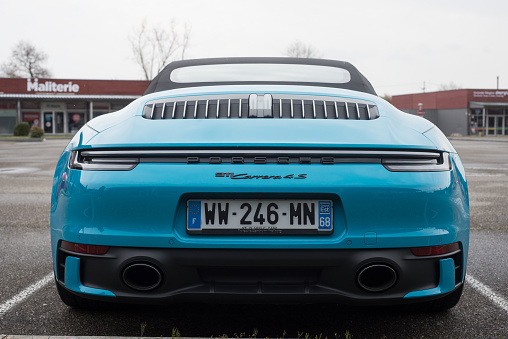Lutterbach - France - 3 April 2022 - Rear view  of blue Porsche 911 carrera 4S convertible parked in the street