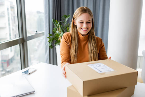 istock Young woman opening a package 1391583110