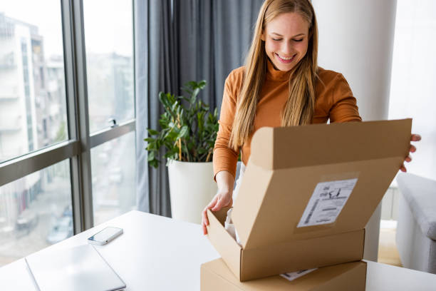 istock Smiling woman opening a delivery box 1391583181