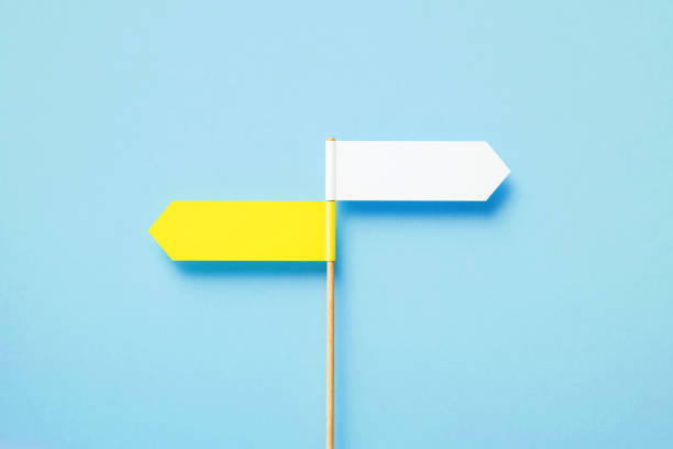 istock Yellow And White Directional Signs Pointing Opposite Directions Over Blue Background 1391583286