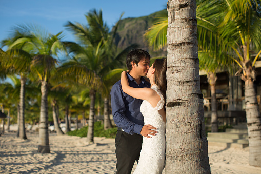 beautiful wedding couple on the beach near palm tree