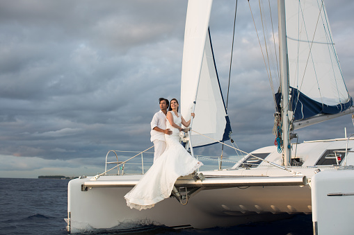 Wedding couple is hugging on a yacht. Beauty bride with groom.