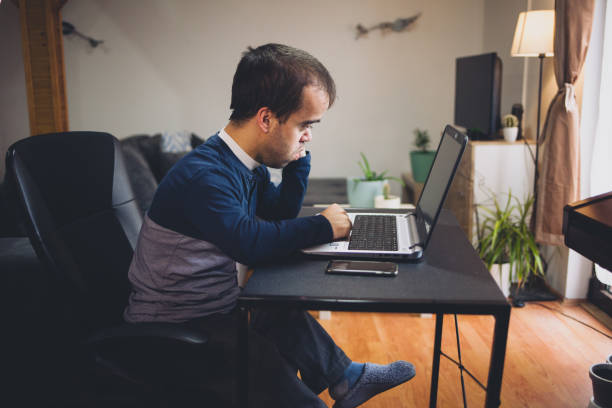 istock Young man with dwarfism working from home 1391584707
