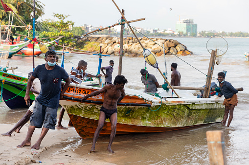 10.03.2022: Sri Lanka. Halle. Fishermen launch a boat into the water.