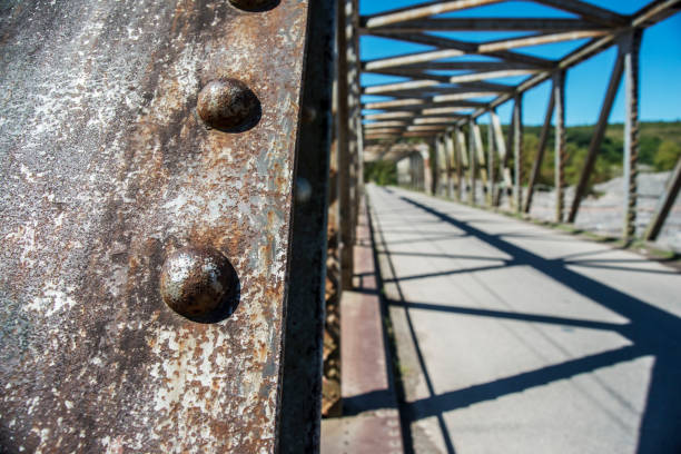 view of an old metal bridge, shaded ground and blue sky