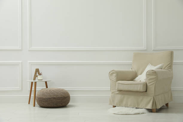 istock Stylish room interior with pouf, armchair and decor elements. Space for text 1391590239