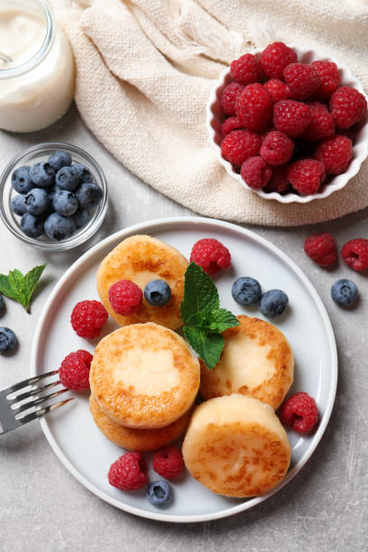 istock Delicious cottage cheese pancakes with berries on light table, flat lay 1391590279