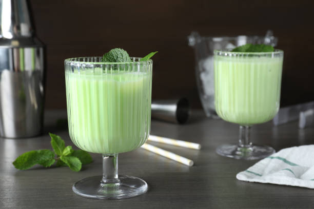 istock Delicious mint liqueur with green leaves on grey wooden table. Space for text 1391590681